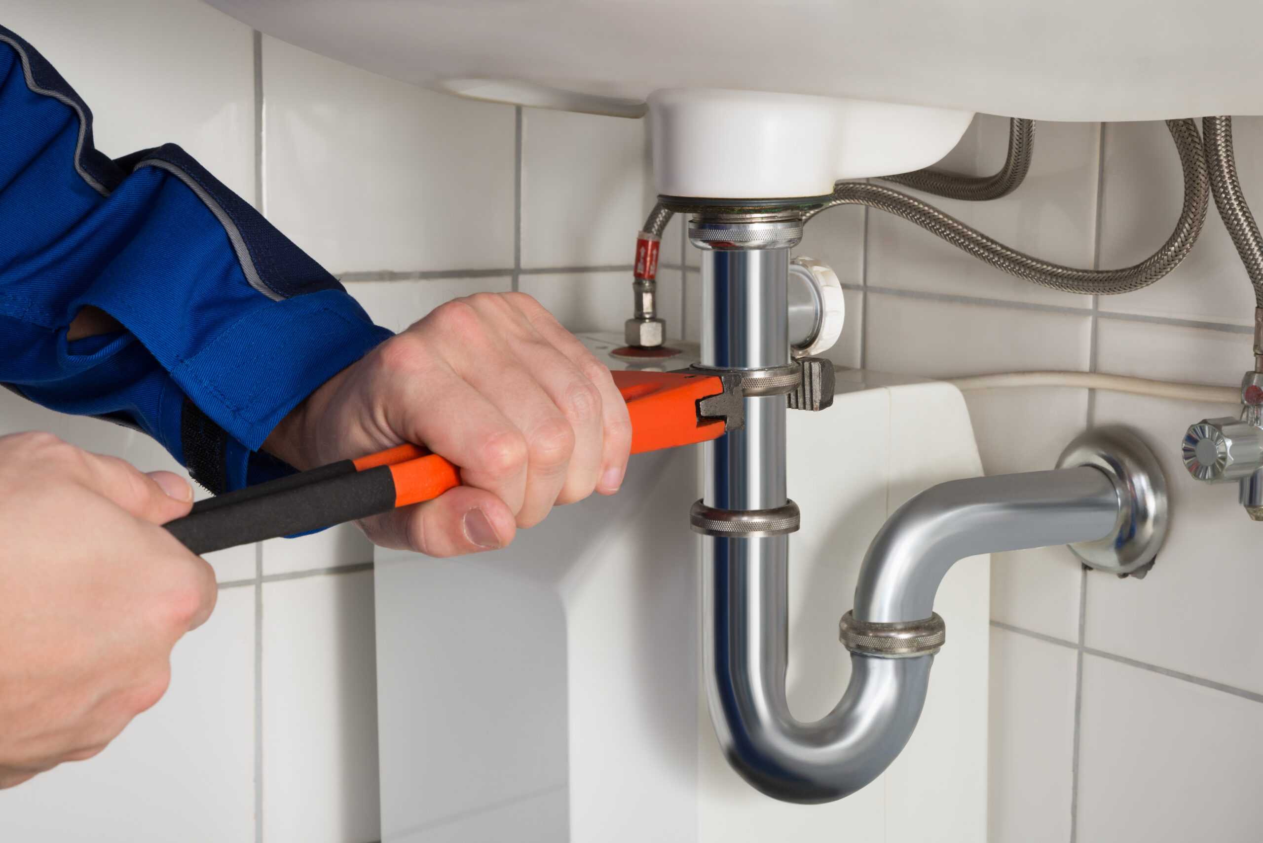 Plumbing repair in Yucca Valley, CA by Hi-Desert Plumbing Inc, focusing on tightening pipes under a sink