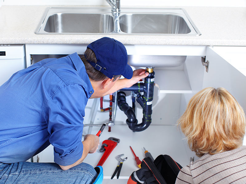Plumber repairing kitchen sink pipes near Yucca Valley, showcasing plumbing services by HI-DESERT PLUMBING INC