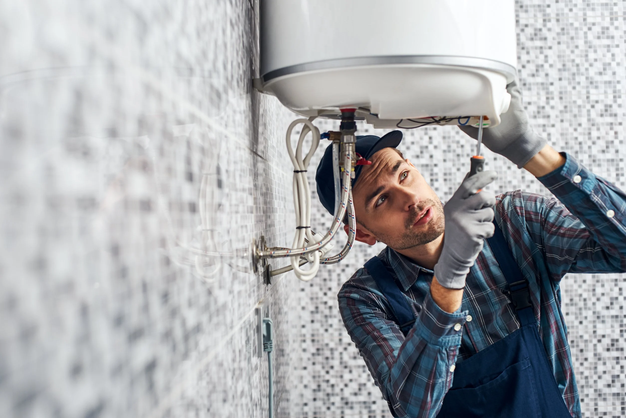 Plumber repairing a water heater for HI-DESERT PLUMBING INC near Yucca Valley